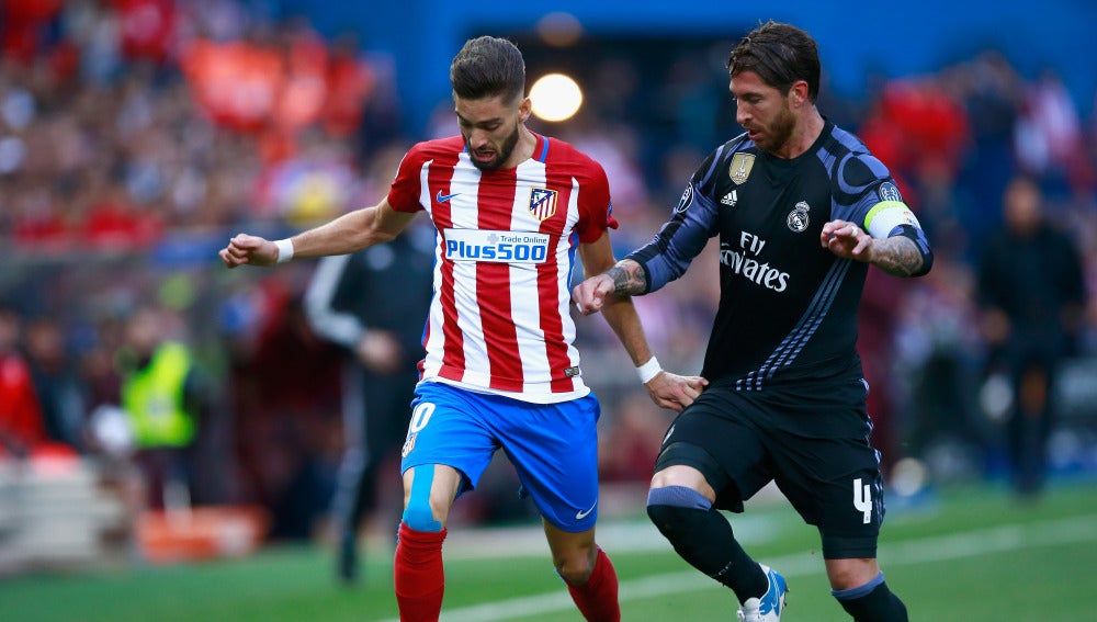 Yannick Carrasco y Sergio Ramos durante el Atlético - Real Madrid