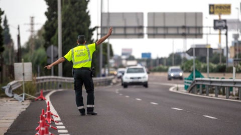 Un agente de la Guardia Civil de Tr&aacute;fico da el alto a un conductor en un control