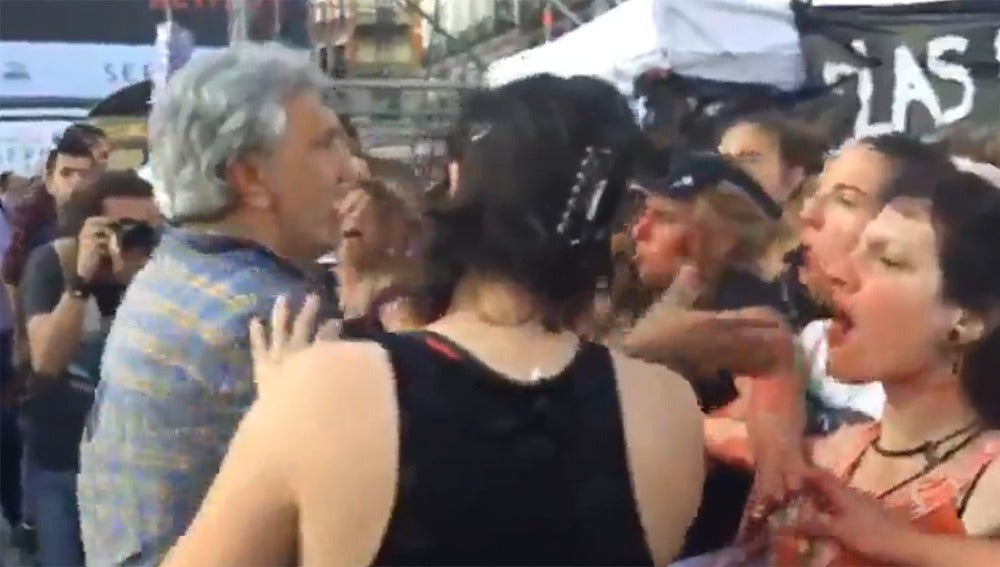 Momento de la agresión de un asistente a la manifestación de Podemos a una feminista