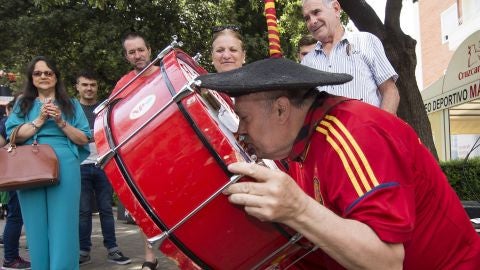 Manolo el del Bombo besa su bombo recuperado junto a su bar en Valencia
