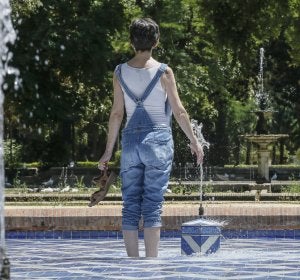 Una chica se refresca del intenso calor en una fuente del parque de Maria Luisa de Sevilla Una chica se refresca del intenso calor en una fuente del parque de Maria Luisa de Sevilla