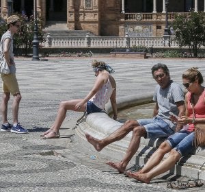 Turistas se refrescan en la plaza de España en Sevilla Turistas se refrescan en la plaza de España en Sevilla