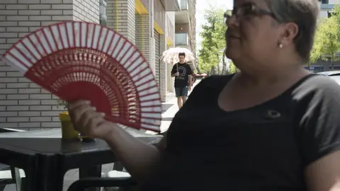 Un mujer se da aire con un abanico Un mujer se da aire con un abanico