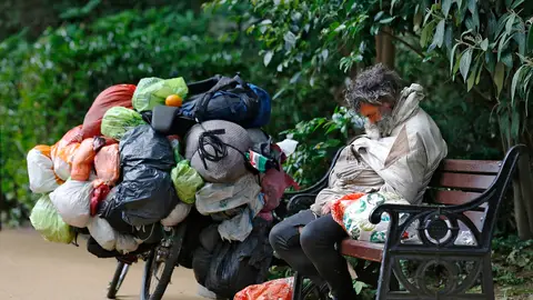Un indigente durmiendo en un banco Un indigente durmiendo en un banco