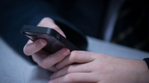 Un ni&ntilde;o consulta un tel&eacute;fono m&oacute;vil (Archivo)