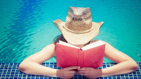 Chica leyendo en la piscina