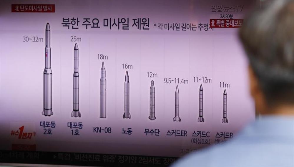 Una persona escucha una información de la televisión sobre el cohete lanzado por Corea del Norte