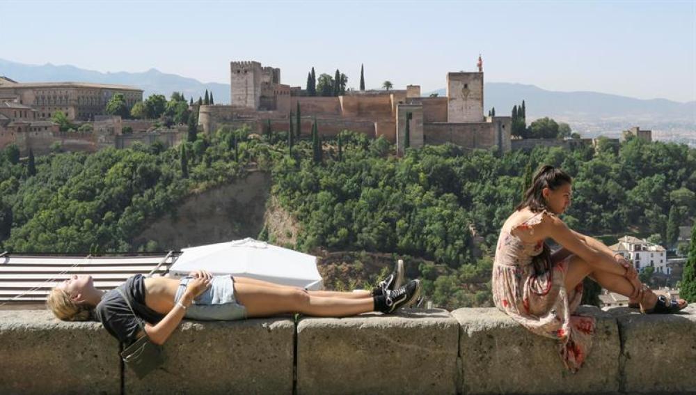 Unos turistas descansan y toman el sol en Granada