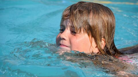 Una niña nada en una piscina