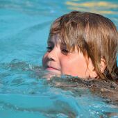 Una niña nada en una piscina