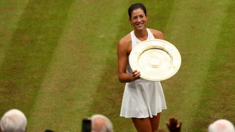 Muguruza sostiene su trofeo de campeona de Wimbledon ante la ovaci&oacute;n de la grada