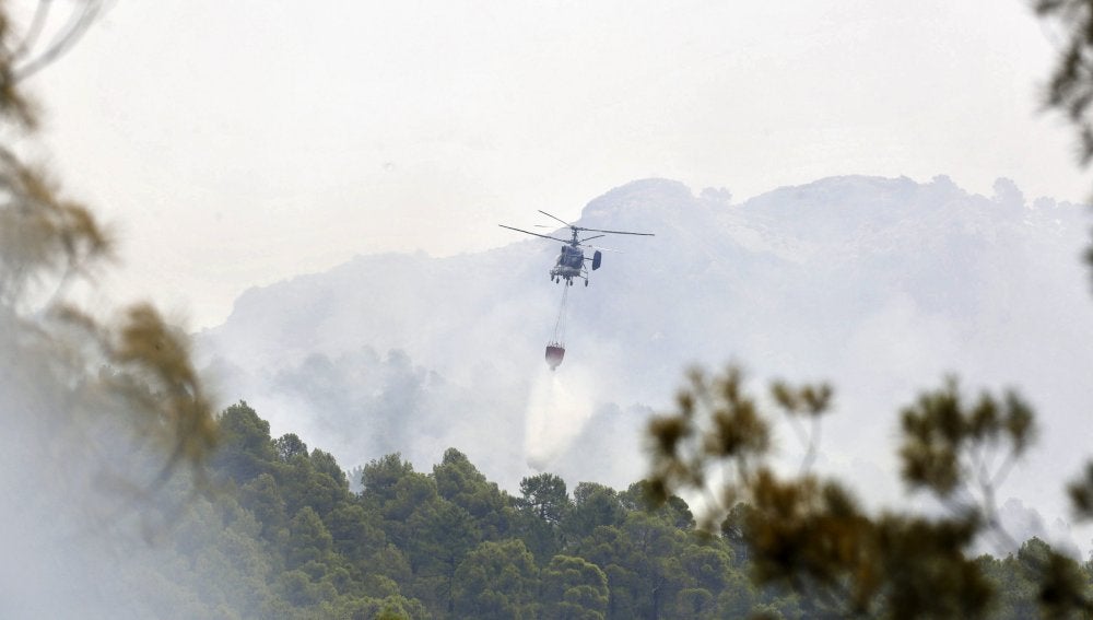 Un helicóptero lanza agua sobre el incendio de Yeste en Albacete