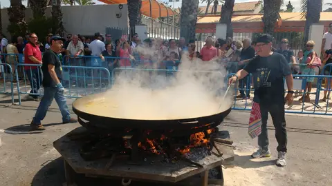 Dos de los cocineros del arroz con costra junto al perol metálico en el que se ha preparado el plato Dos de los cocineros del arroz con costra junto al perol metálico en el que se ha preparado el plato