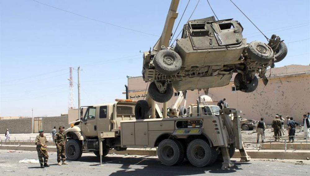 Retirada de un vehículo militar dañado tras el atentado suicida en Afganistán