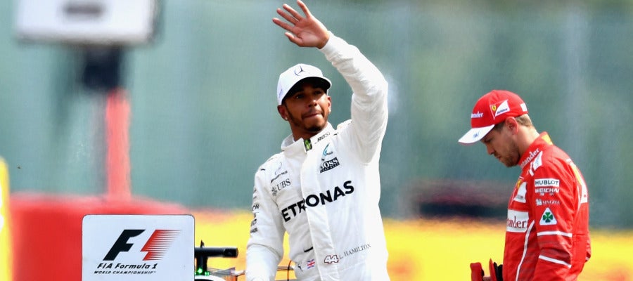 Lewis Hamilton saluda al público con Vettel cabizbajo al fondo Lewis Hamilton saluda al público con Vettel cabizbajo al fondo