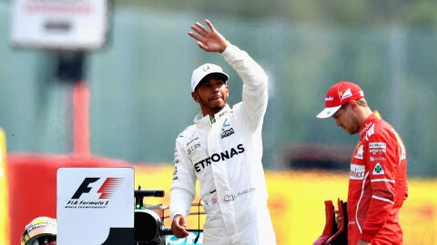 Lewis Hamilton saluda al p&uacute;blico con Vettel cabizbajo al fondo