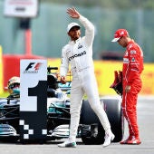 Lewis Hamilton saluda al público con Vettel cabizbajo al fondo