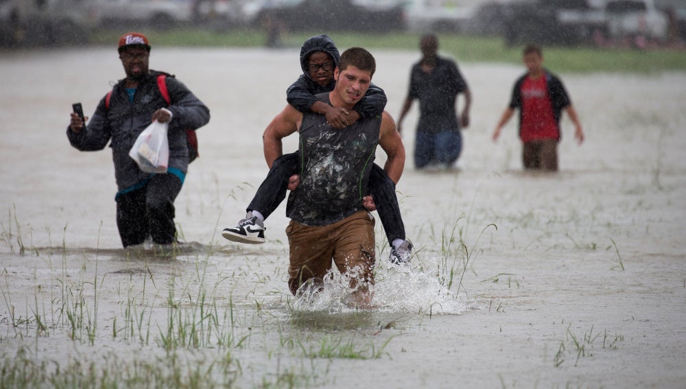 Un hombre ayuda a evacuar a un chico en Houston