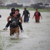 Un hombre ayuda a evacuar a un chico en Houston