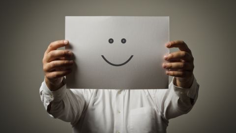 Un hombre sujeta una cara sonriente