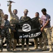 Unos soldados de Daesh exhiben su bandera