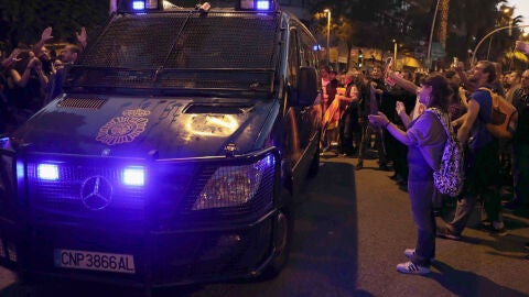 Efectivos de la la Policia Nacional abandonan las inmediaciones de la sede de la CUP en Barcelona ante los aplausos de los centenares de simpatizantes que se han concentrado desde este mediod&iacute;a para intentar impedir un posible registro de las oficinas de la entidad.