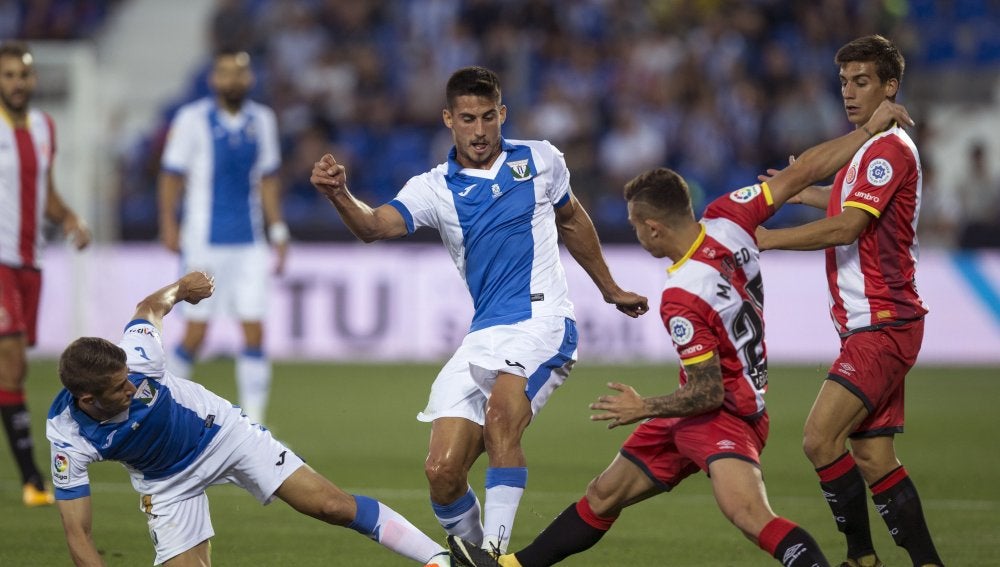 Szymanowski y Pires disputan el balón durante el Leganés - Girona