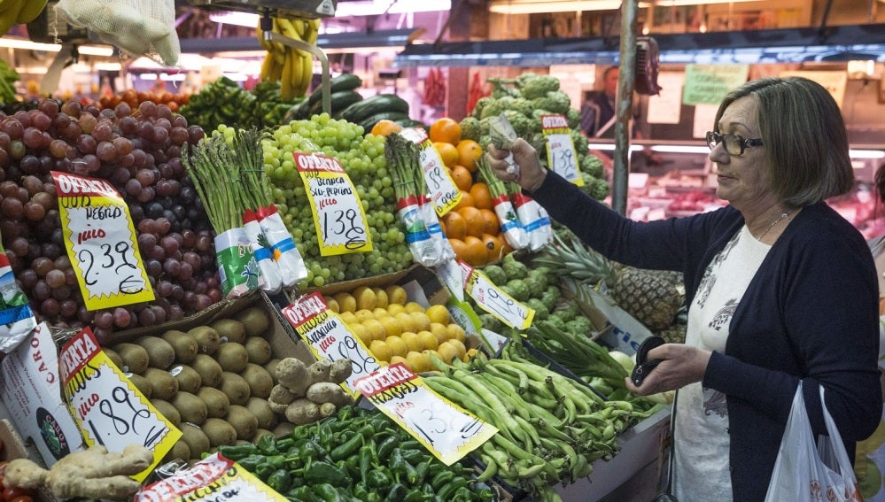 En la imagen, una mujer hace su compra en una frutería del mercado Maravilla en Madrid.