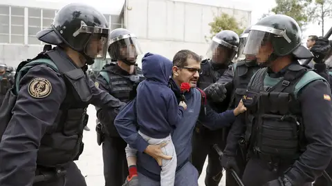 Un padre con su hijo en brazos y rodeado de antidusturbios Un padre con su hijo en brazos y rodeado de antidusturbios