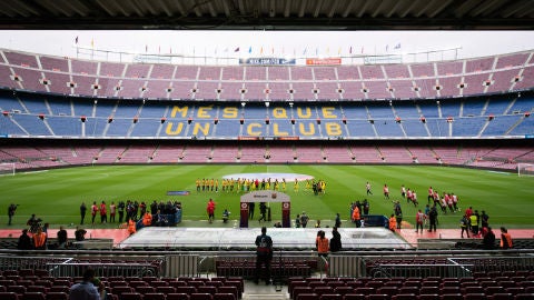Los jugadores se chocan la mano en un Camp Nou completamente vac&iacute;o
