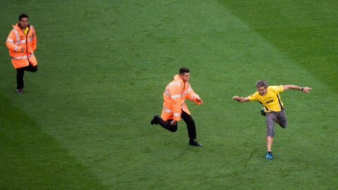 Un aficionado sortea el placaje de un miembro de seguridad en el partido del Bar&ccedil;a a puerta cerrada