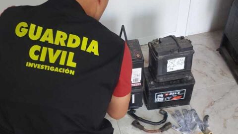 Un agente de la Guardia Civil junto a alguna de las baterias de cami&oacute;n robadas