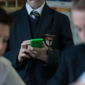 Un alumno con un móvil en el colegio