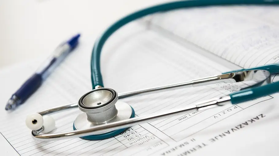 Estetoscopio al lado de un informe médico La paciente fue trasladada a un hospital público