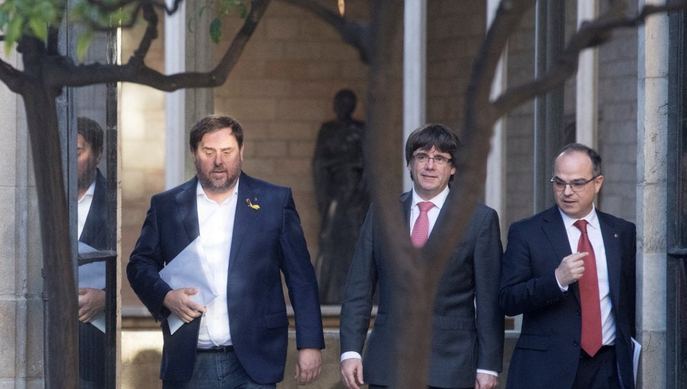 Carles Puigdemont, president de la Generalitat, entre el vicepresident, Oriol Junqueras, y el portavoz del Govern, Jordi Turull