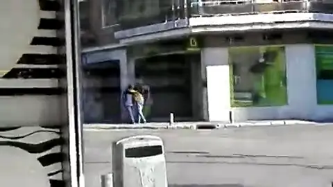 Así ha sido el momento en el que el atracador de Usera salía del banco apuntando a un rehén con el arma Así ha sido el momento en el que el atracador de Usera salía del banco apuntando a un rehén con el arma