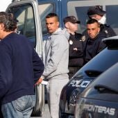 Varios inmigrantes suben en una furgoneta de la policía nacional 