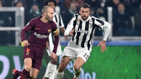 Iniesta conduce el bal&oacute;n ante la mirada de Marchisio. 