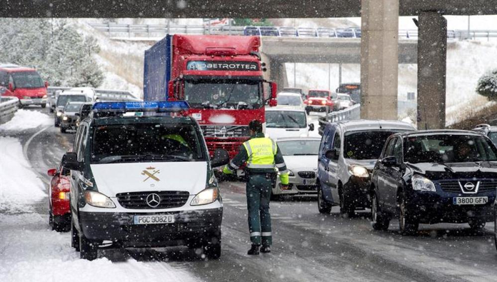 Numerosos vehículos circulan entre la nieve en una retención en la A-1 en las inmediaciones de Burgos.