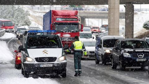Numerosos veh&iacute;culos circulan entre la nieve en una retenci&oacute;n en la A-1 en las inmediaciones de Burgos.