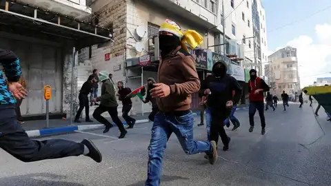 Palestinos corren durante enfrentamientos surgidos entre manifestantes y soldados israelíes Palestinos corren durante enfrentamientos surgidos entre manifestantes y soldados israelíes