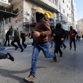Palestinos corren durante enfrentamientos surgidos entre manifestantes y soldados israelíes