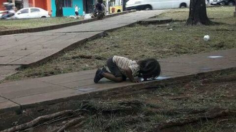Una ni&ntilde;a bebiendo de un charco