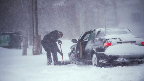 Un hombre quita la nieve de su coche en Nueva York