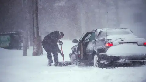 Un hombre quita la nieve de su coche en Nueva York Un hombre quita la nieve de su coche en Nueva York