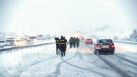  Efectivos de la Unidad Militar de Emergencia (UME) trabajan para liberar a los veh&iacute;culos atrapados por la nieve en la AP6
