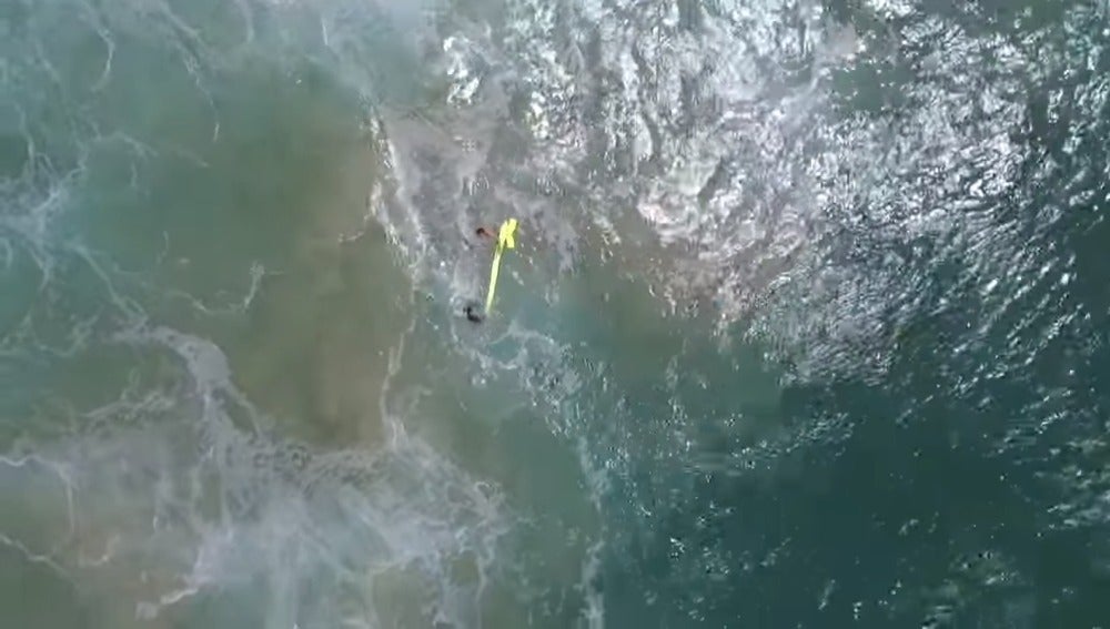 Momento del rescate de un dron a dos surfistas