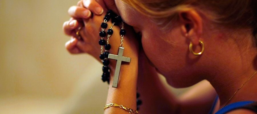 Mujer rezando en una iglesia Mujer rezando en una iglesia