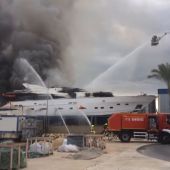 Continúan las tareas de extinción del aparatoso incendio de un yate en dique seco en la zona portuaria de Alicante