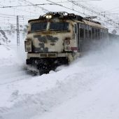 Un tren transita entre la nieve en la estación de ferrocarril de Busdongo, en las proximidades del puerto de Pajares,